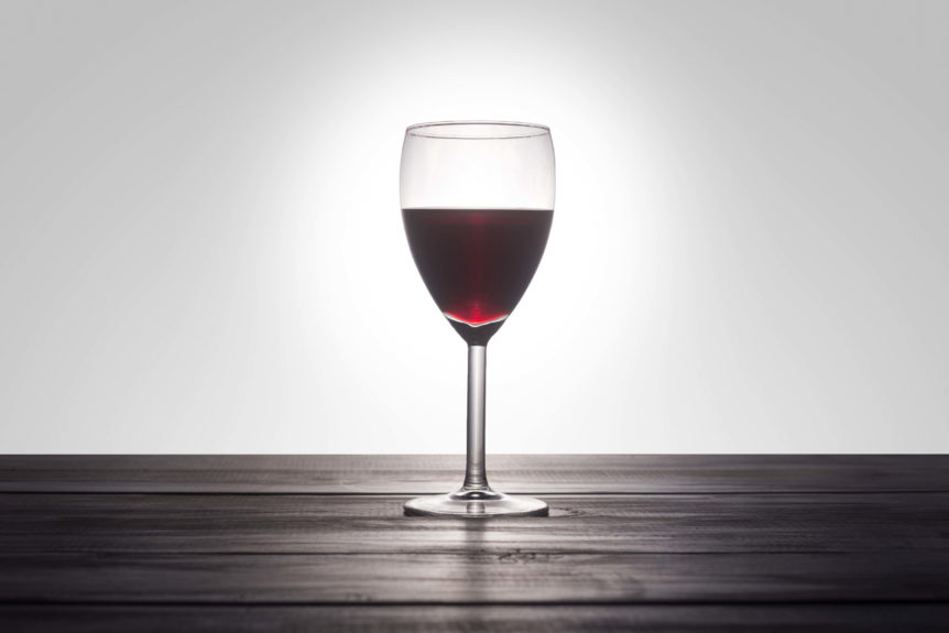 Glass of wine on clean wooden floor